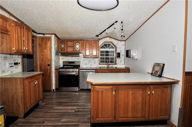 kitchen with kitchen peninsula, sink, a textured ceiling, and appliances with stainless steel finishes