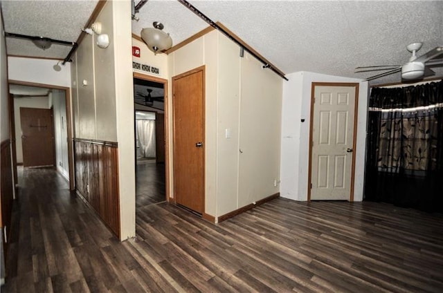 interior space featuring dark hardwood / wood-style flooring, a textured ceiling, and vaulted ceiling