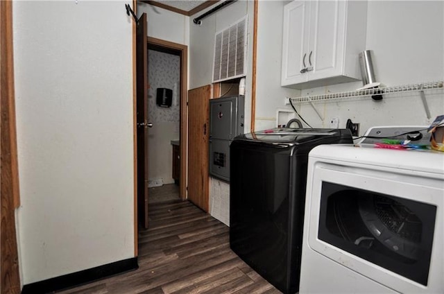 laundry area featuring cabinets, washing machine and dryer, and dark wood-type flooring