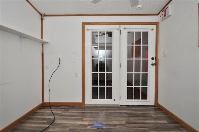 doorway with crown molding, dark hardwood / wood-style flooring, and a textured ceiling