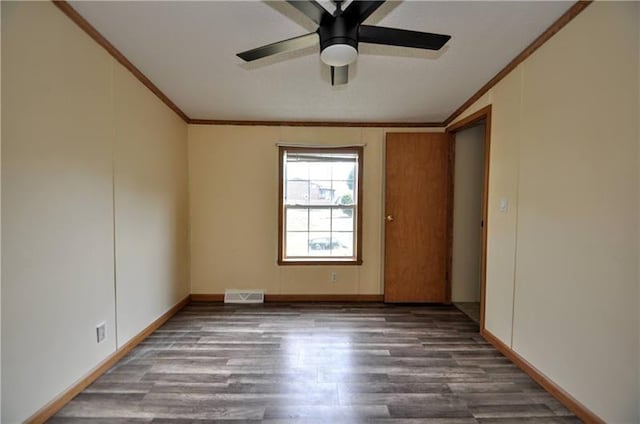 empty room with ceiling fan, dark hardwood / wood-style flooring, and crown molding