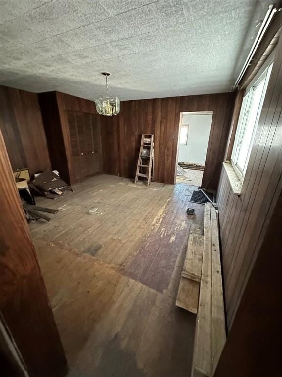 interior space featuring wooden walls and a chandelier