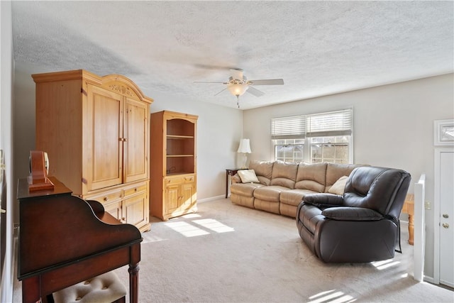 living room with light carpet, ceiling fan, and a textured ceiling