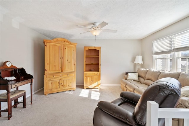 living room with light carpet, ceiling fan, and a textured ceiling