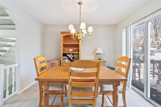 carpeted dining room featuring an inviting chandelier