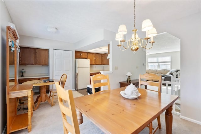 carpeted dining space featuring an inviting chandelier