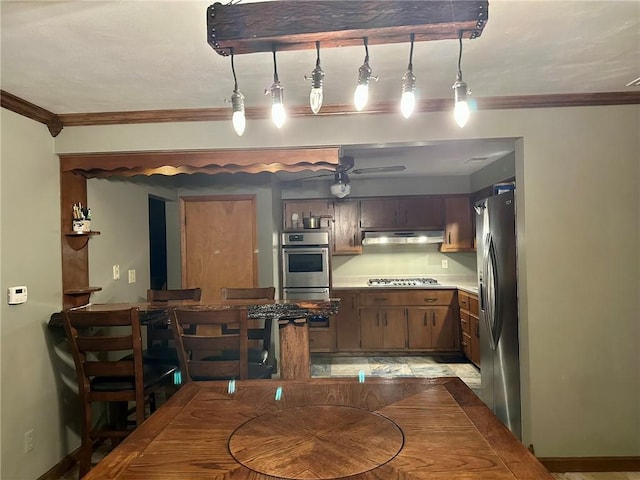 dining area with ceiling fan and crown molding