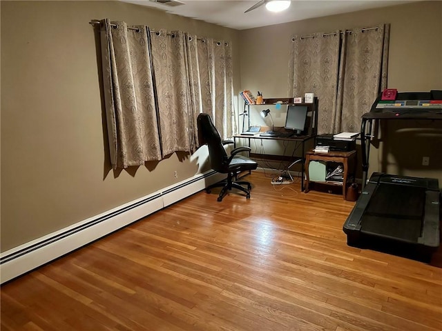 office area featuring ceiling fan, light hardwood / wood-style floors, and a baseboard heating unit