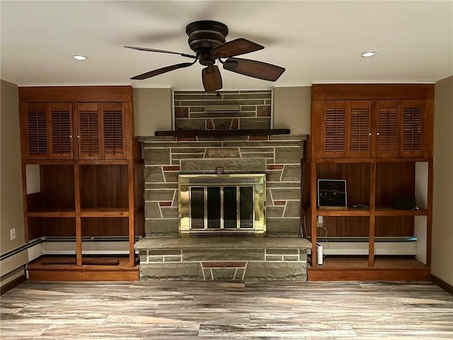 unfurnished living room featuring a fireplace, light wood-type flooring, baseboard heating, and ceiling fan