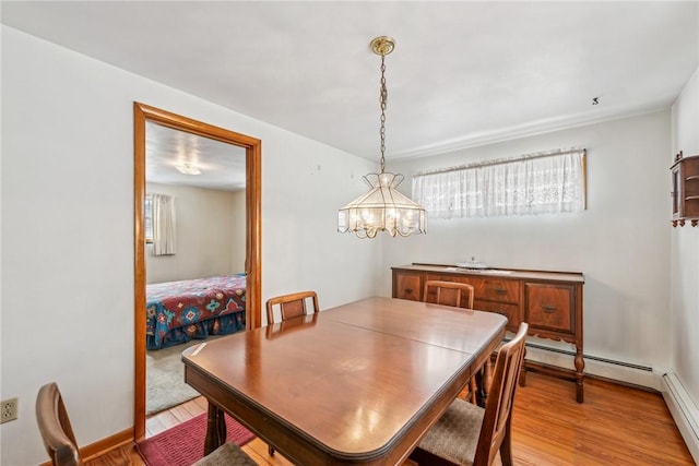 dining area with light wood-type flooring and a notable chandelier