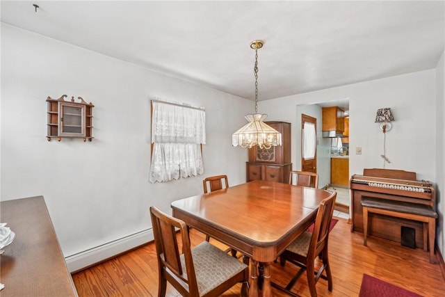 dining room with a chandelier, a baseboard radiator, and hardwood / wood-style flooring