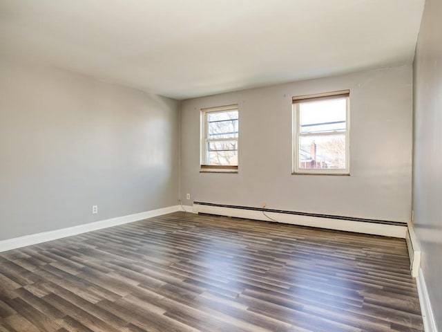 unfurnished room featuring dark hardwood / wood-style floors and baseboard heating