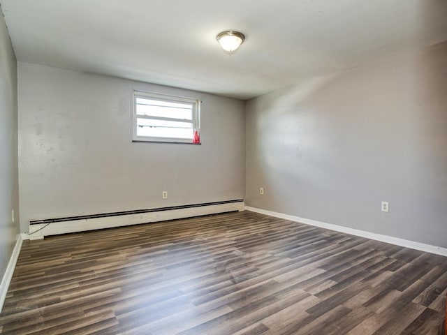 spare room featuring dark hardwood / wood-style floors and a baseboard heating unit