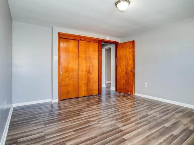 unfurnished bedroom featuring wood-type flooring and a closet