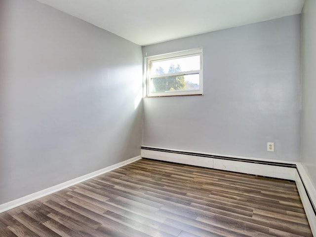 spare room with hardwood / wood-style flooring and a baseboard radiator