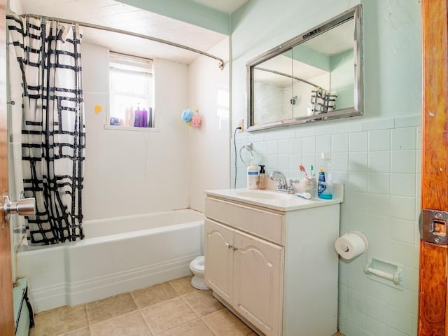 full bathroom featuring shower / bath combo with shower curtain, vanity, tile walls, and toilet