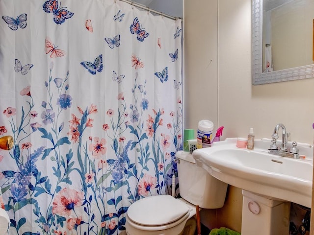 bathroom featuring a shower with shower curtain and toilet