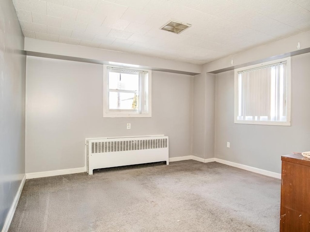 unfurnished room featuring carpet flooring and radiator