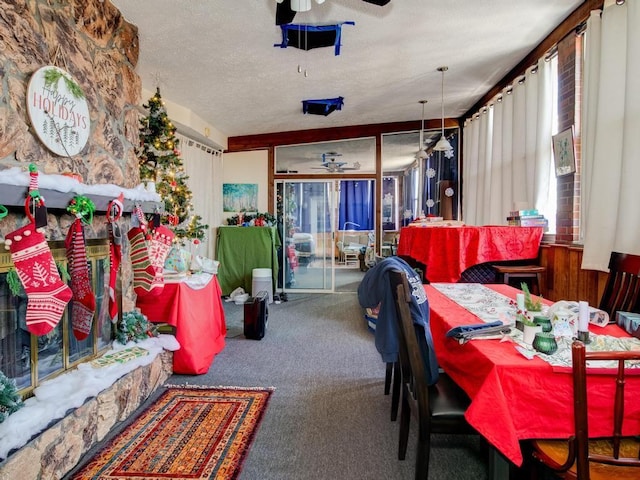 dining space with a textured ceiling, carpet floors, and ceiling fan