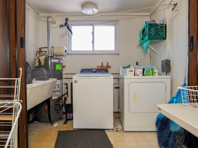 clothes washing area with water heater and washer and dryer