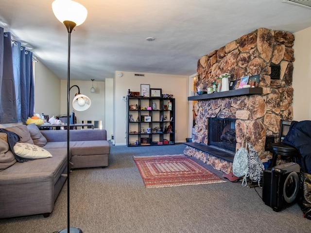 carpeted living room featuring a stone fireplace