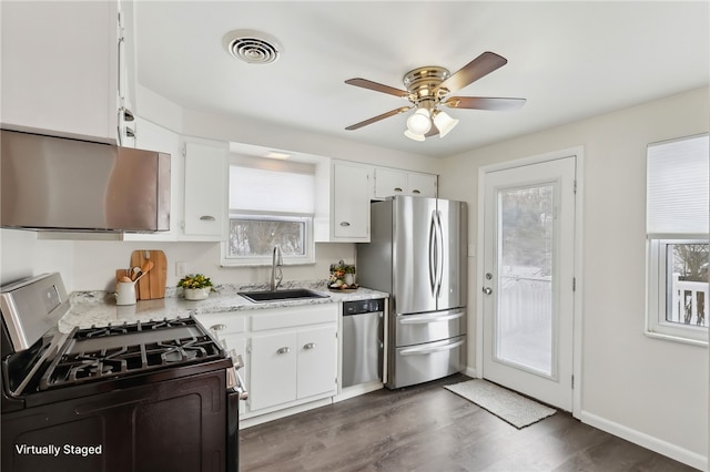 kitchen featuring white cabinets, appliances with stainless steel finishes, a healthy amount of sunlight, and sink