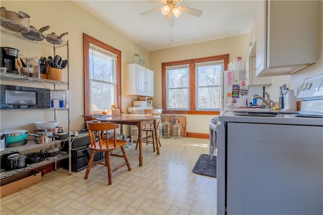 kitchen featuring white cabinets, white electric range, ceiling fan, and radiator