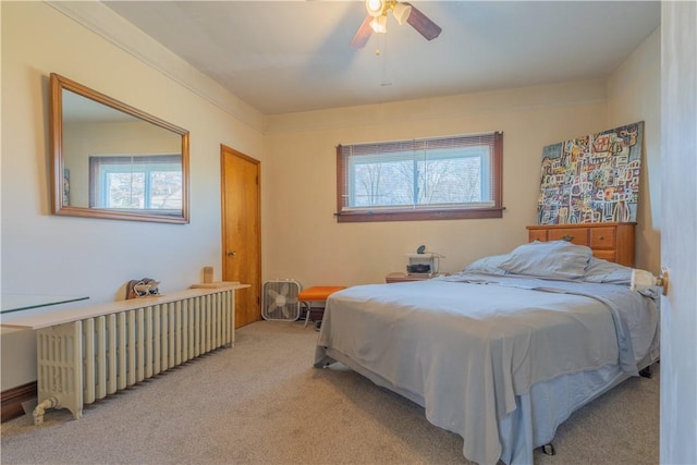 carpeted bedroom featuring radiator and ceiling fan