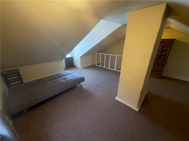 bonus room with vaulted ceiling and dark colored carpet