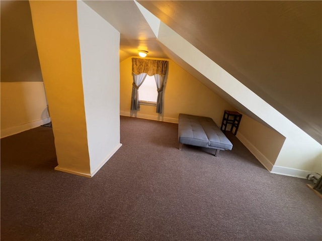 additional living space featuring vaulted ceiling and dark colored carpet