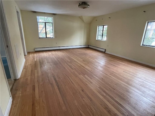 spare room with a baseboard heating unit and light wood-type flooring