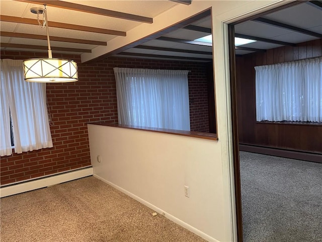 carpeted empty room featuring baseboard heating and beamed ceiling