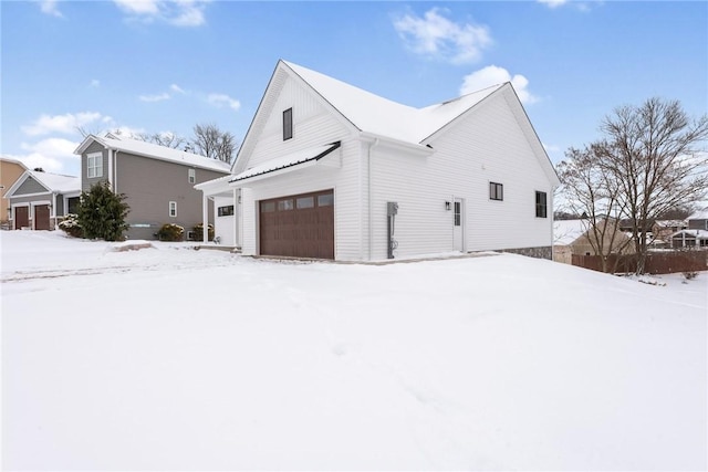 snow covered property featuring a garage