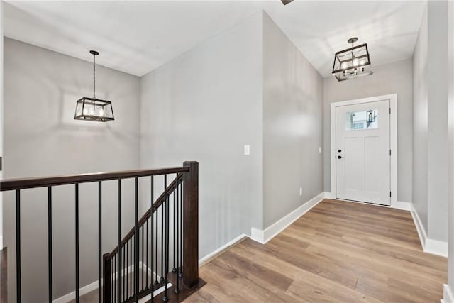 entryway with light hardwood / wood-style flooring and an inviting chandelier