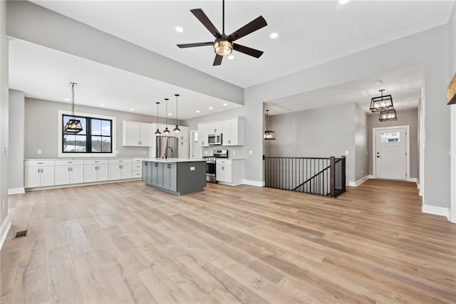 unfurnished living room featuring ceiling fan and light hardwood / wood-style flooring