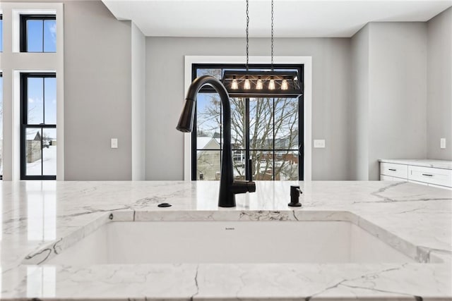 interior details featuring light stone countertops and decorative light fixtures