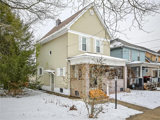 view of snow covered back of property