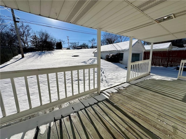 snow covered deck featuring a shed