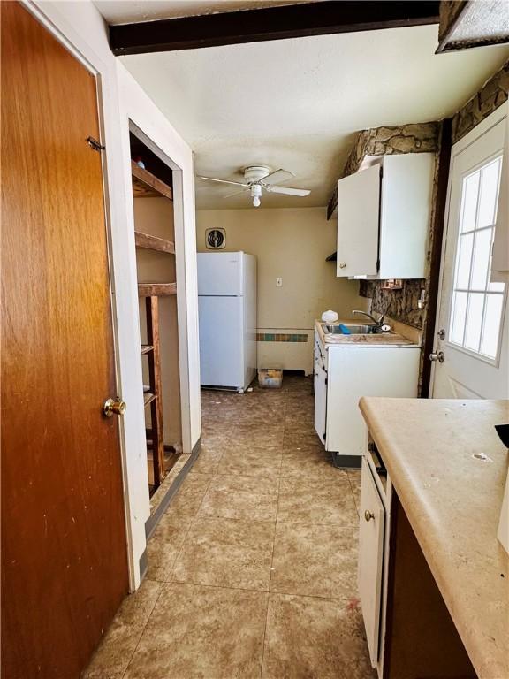 kitchen featuring radiator, white cabinetry, white fridge, and ceiling fan