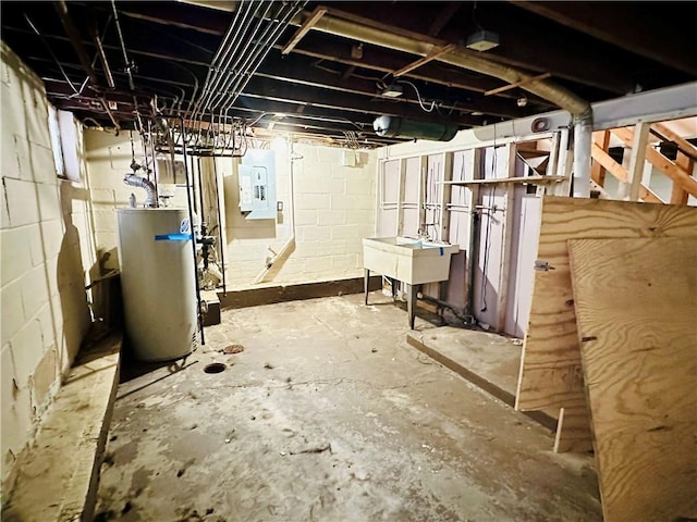 basement featuring sink, electric panel, and water heater