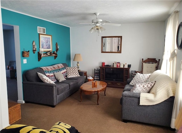 carpeted living room featuring ceiling fan and a textured ceiling