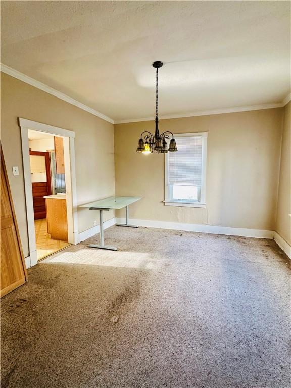 unfurnished dining area featuring crown molding and an inviting chandelier