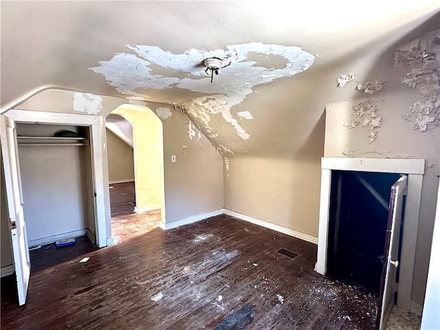 bonus room with dark wood-type flooring and vaulted ceiling