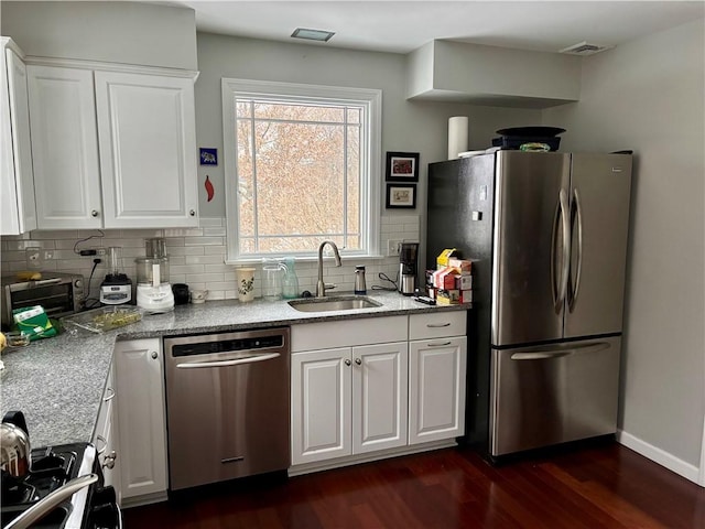 kitchen with sink, light stone countertops, appliances with stainless steel finishes, and white cabinetry