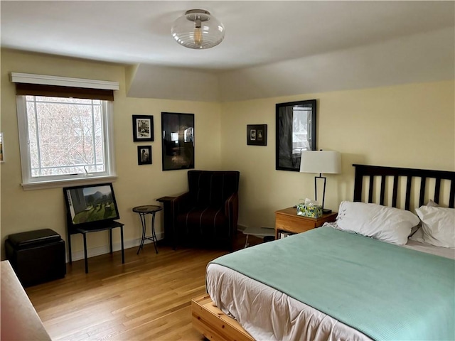 bedroom featuring light wood-type flooring and vaulted ceiling