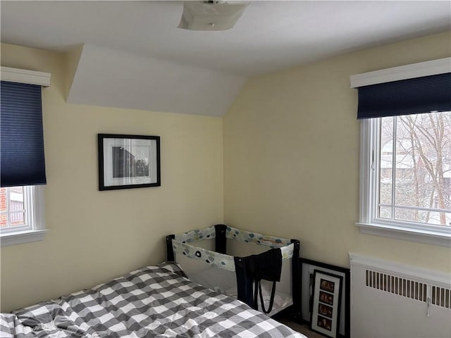 bedroom with radiator heating unit and vaulted ceiling