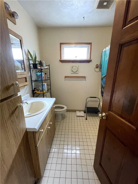 bathroom with tile patterned floors, vanity, and toilet