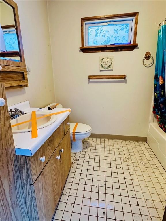 full bathroom with tile patterned flooring, vanity, shower / tub combo, and toilet