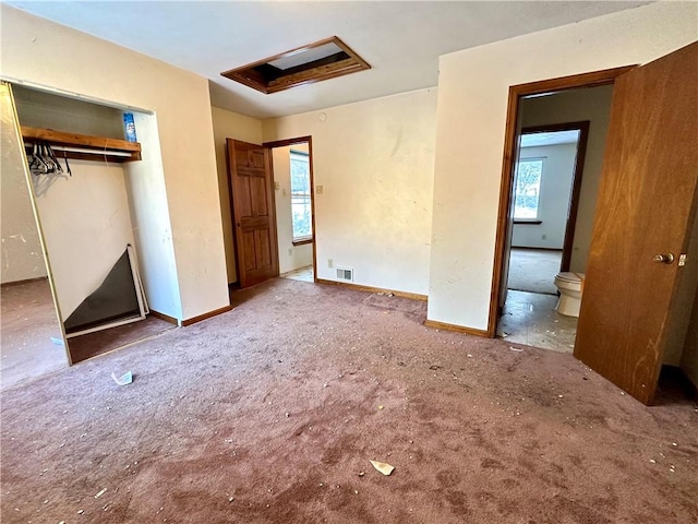 unfurnished bedroom with carpet flooring, connected bathroom, and a closet