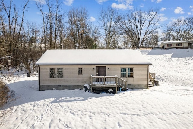 snow covered back of property featuring a wooden deck